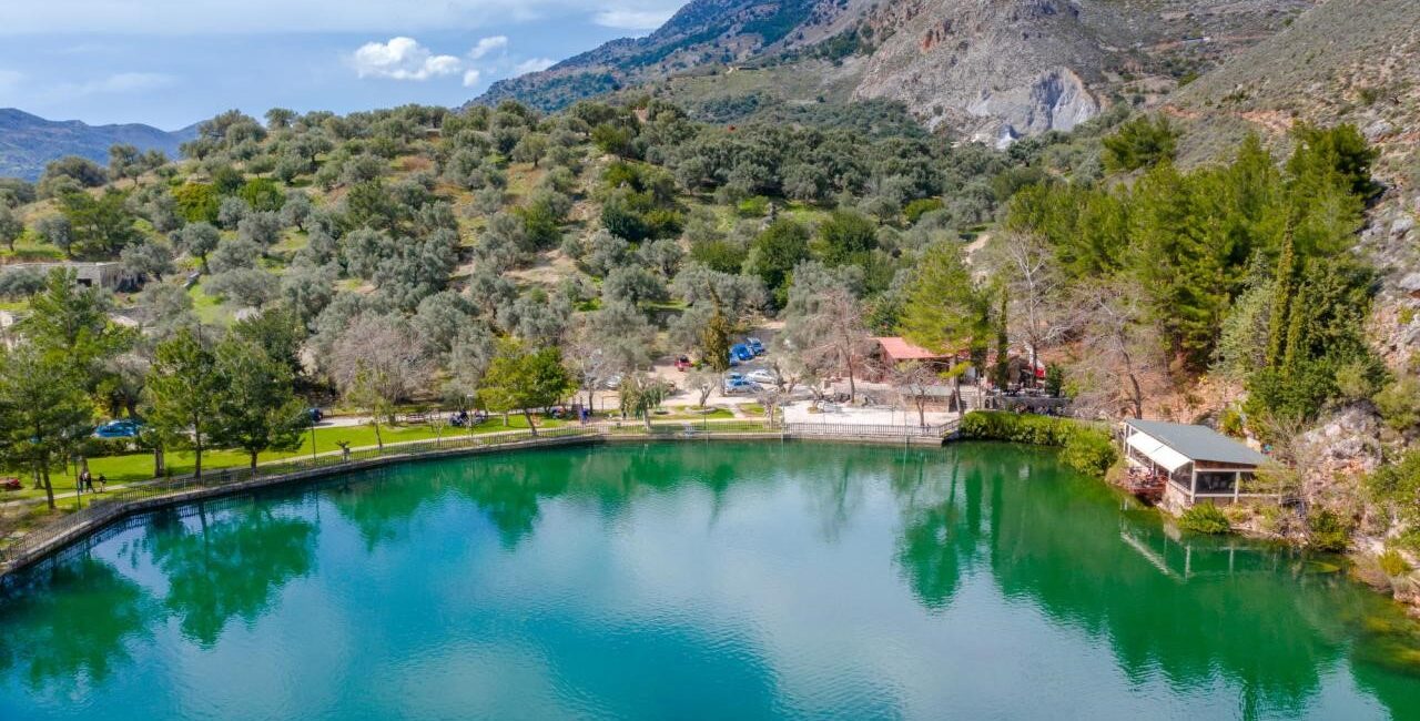 Zaros Lake: A panoramic view of the tranquil waters of Zaros lake and its surroundings blends in with the greenery of the area."