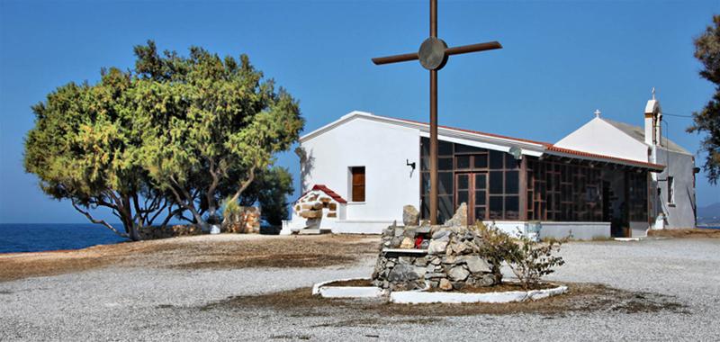 The little white-colored church of Agioi Apostoloi, with a big wooden cross in its square