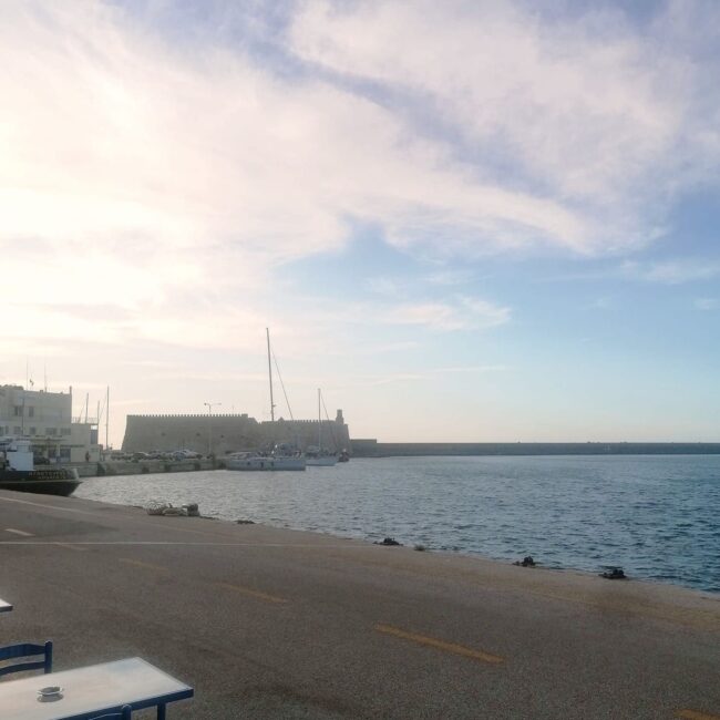 Erasitexnes Psarades: A meal during sunset with the Venetian Fortress as the background